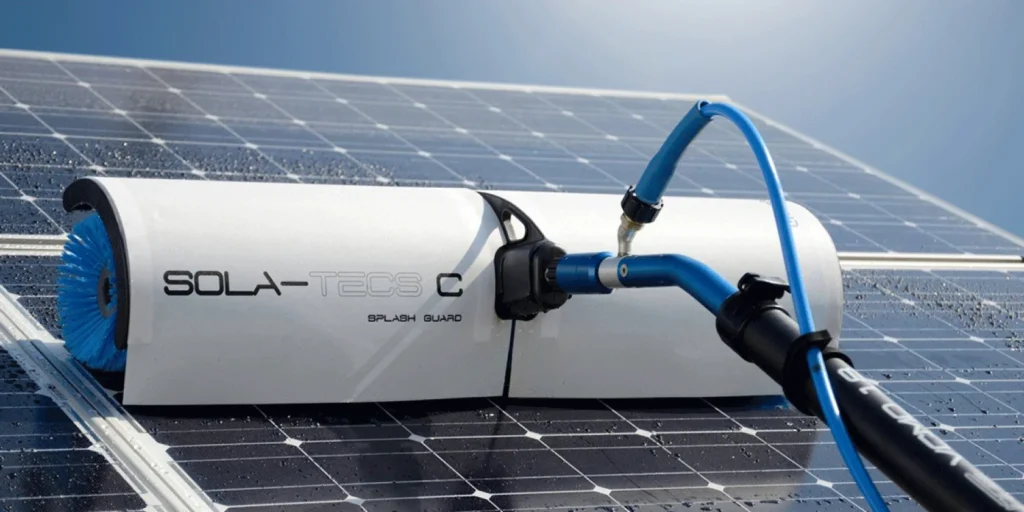 Reinigungsroboter für Solarpanels der Marke Sola-Tecs C, ausgestattet mit einer blauen Bürste und Spritzschutz, montiert auf Solarzellen.